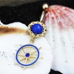 Piercing nombril plaqu� or et bleu � barre (roue) de bateau